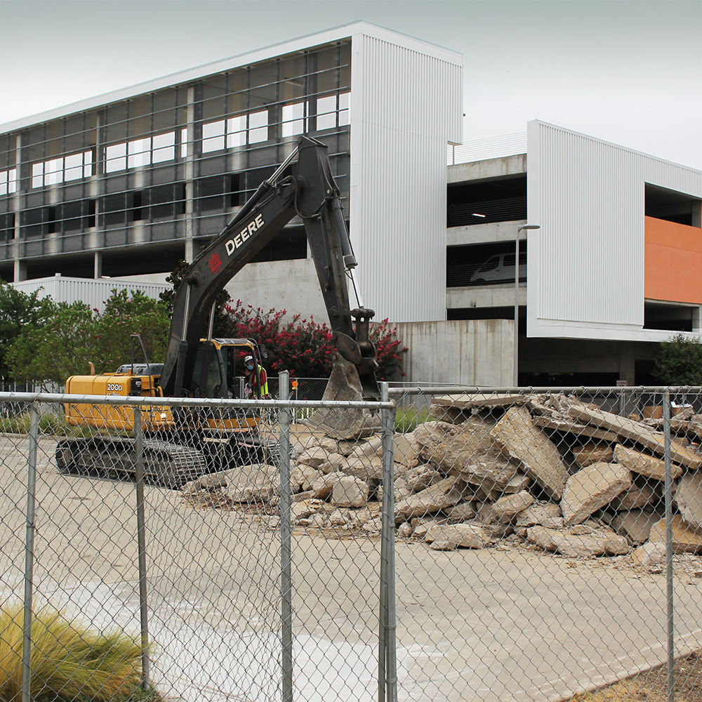 A crane helps break up and haul away another section of Rutford Avenue to make way for a pedestrian promenade.