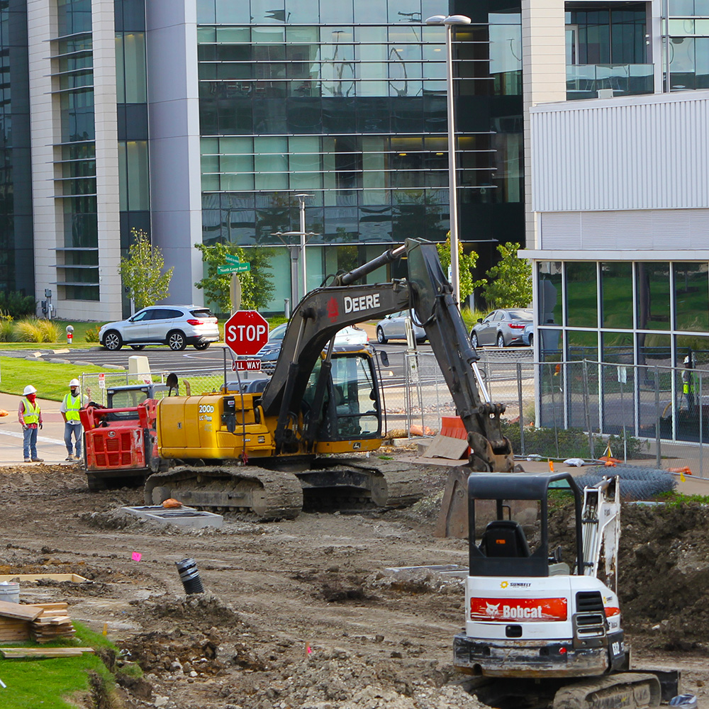 Workers with digging equipment continue the conversion of Rutford Avenue, from a road into a pedestrian promenade.