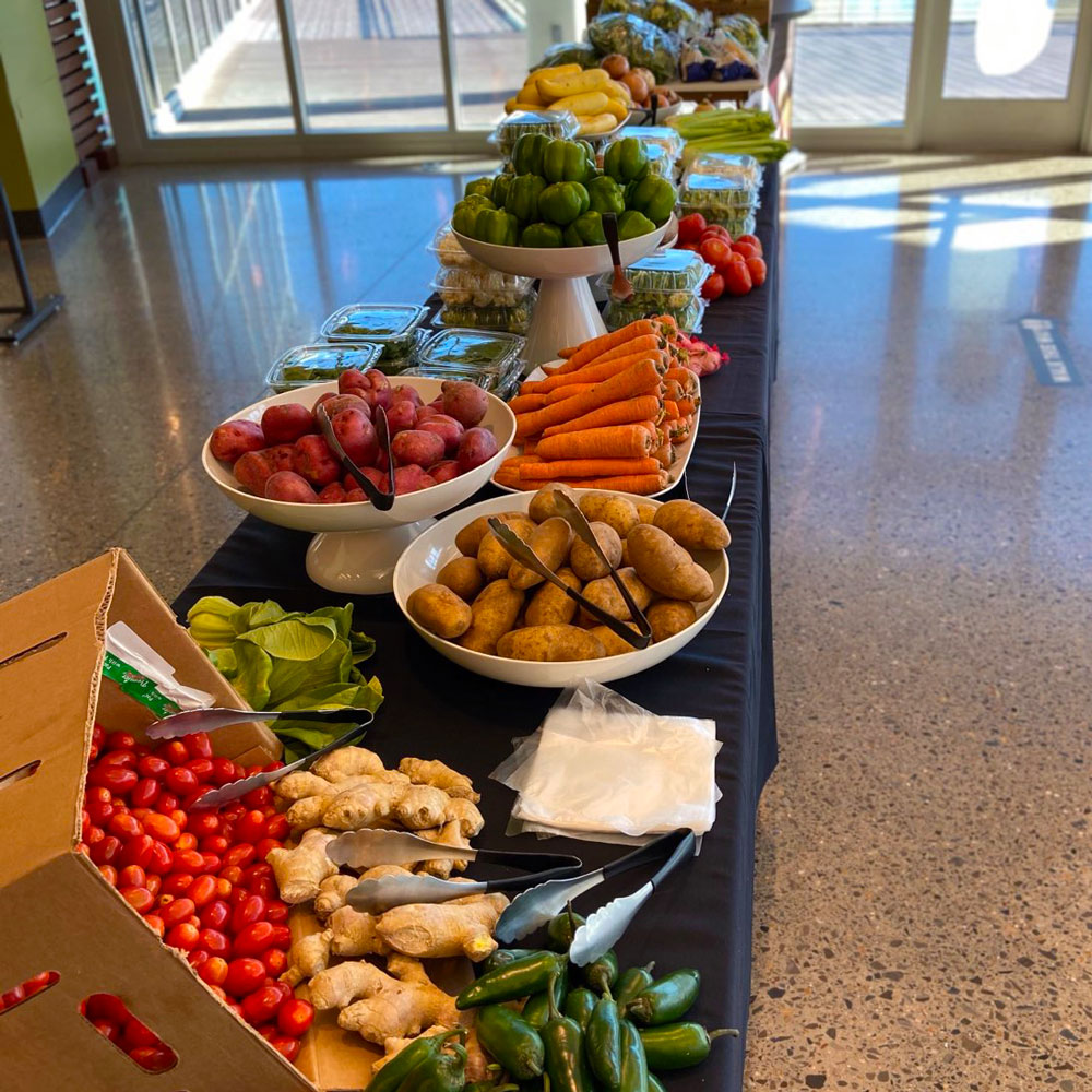 A long table piled high with fresh vegetables.