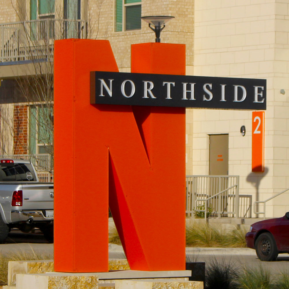 The Northside sign, a large orange “N” partially overlapped by a dark recatangle, within which reads “Northside.”