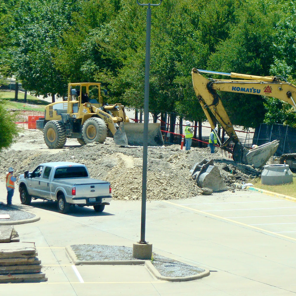 Construction equipment breaks up asphalt.