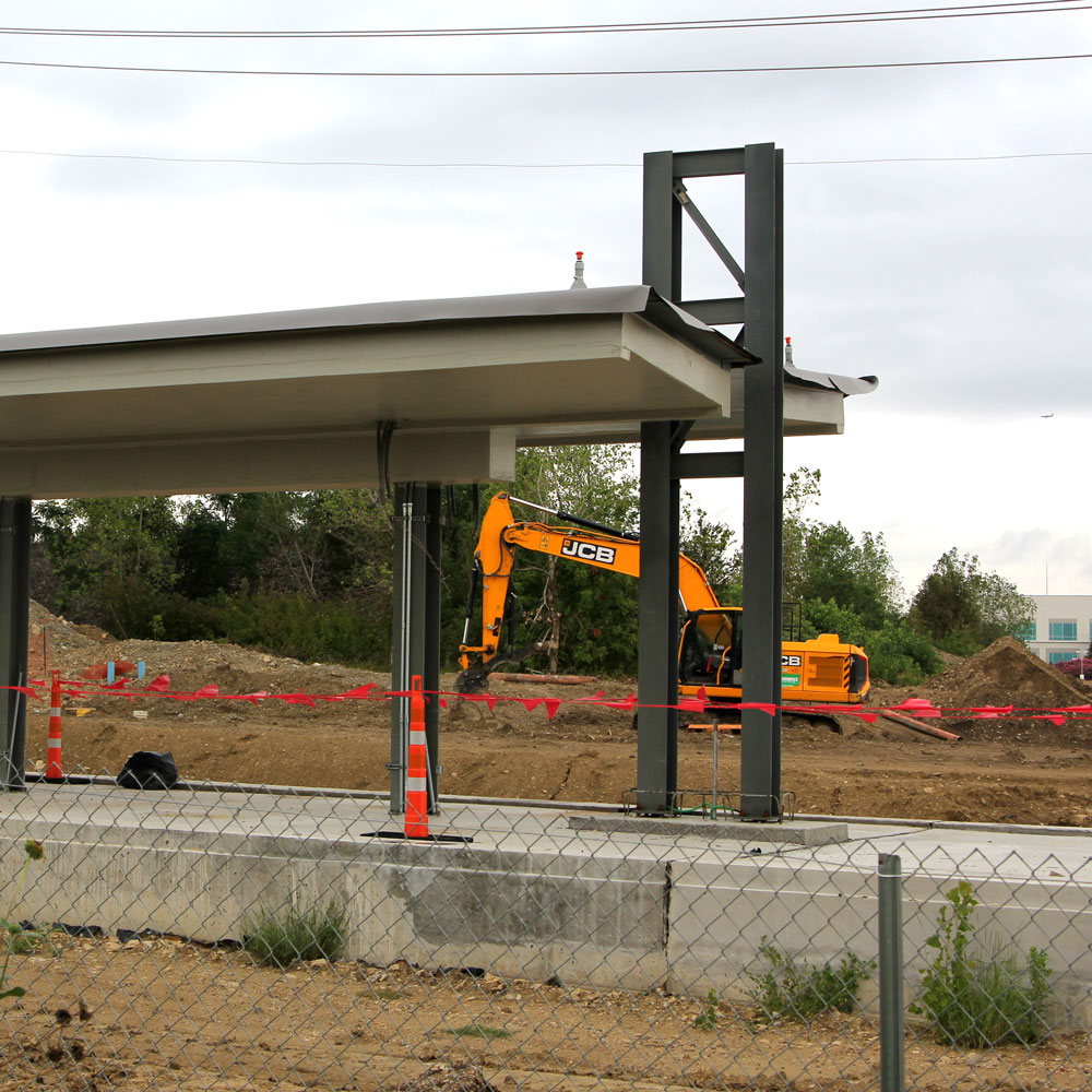 A train platform under construction, with a digging machine in the background.