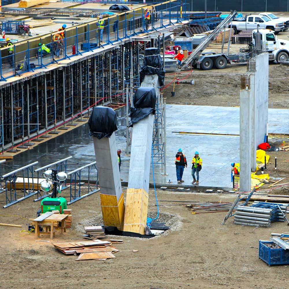 A pair of angled concrete columns form a “V” shape as they rise out of the ground.