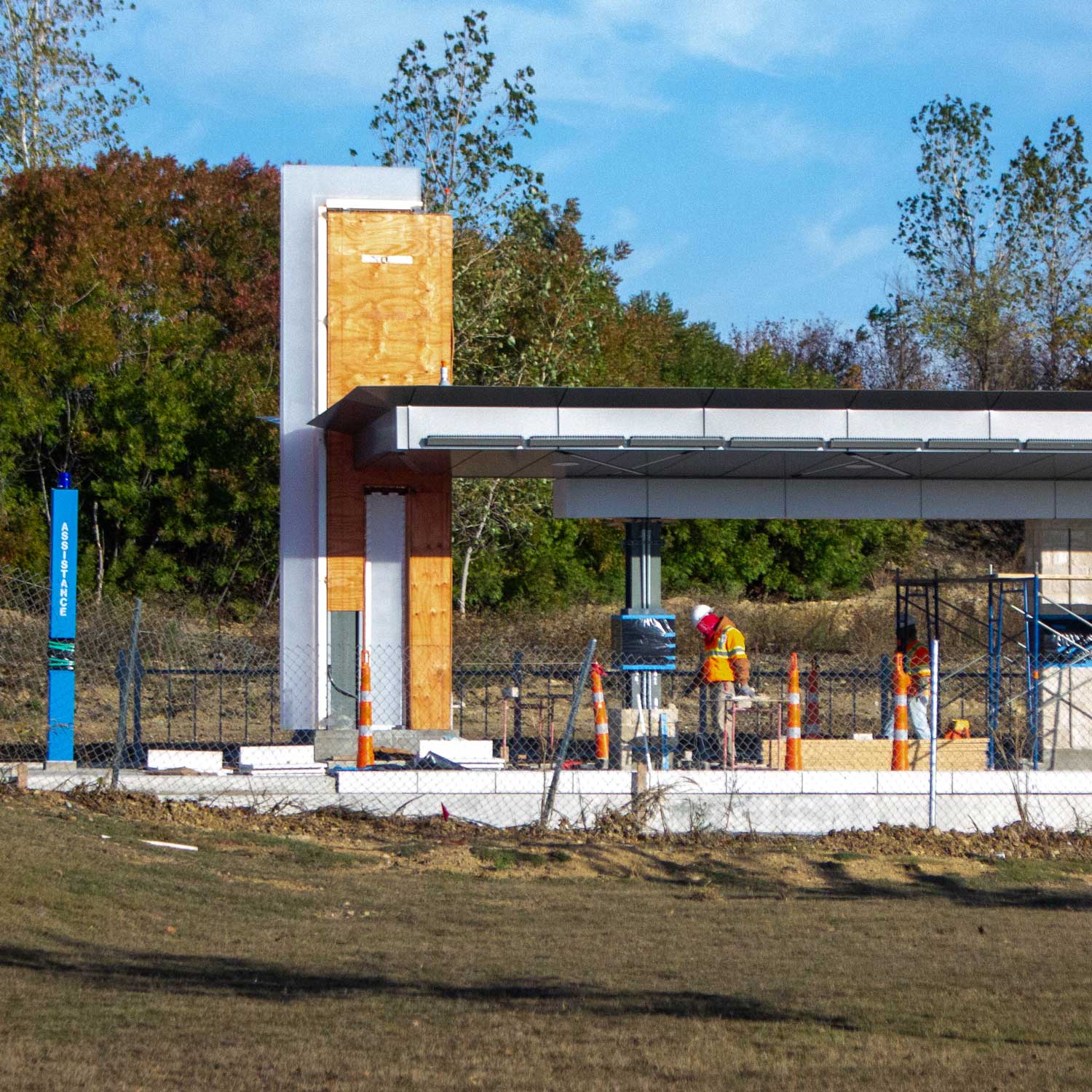 A construction worker walks across a partially-completed train platform.