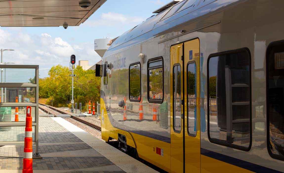 The under-construction DART station reflected back in the train’s panels.