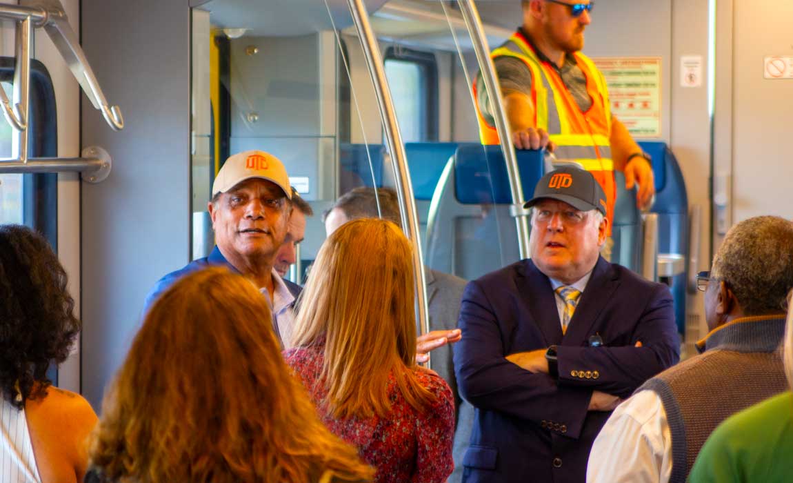 Dr. Calvin D. Jamison, vice president for Facilities & Economic Development (left, facing forward) and Dr. Richard C. Benson, president of The University of Texas at Dallas (right, facing forward), joined members of the Transit Coalition of North Texas, Comets for Better Transit, and officials from surrounding cities on board the new Silver Line train.