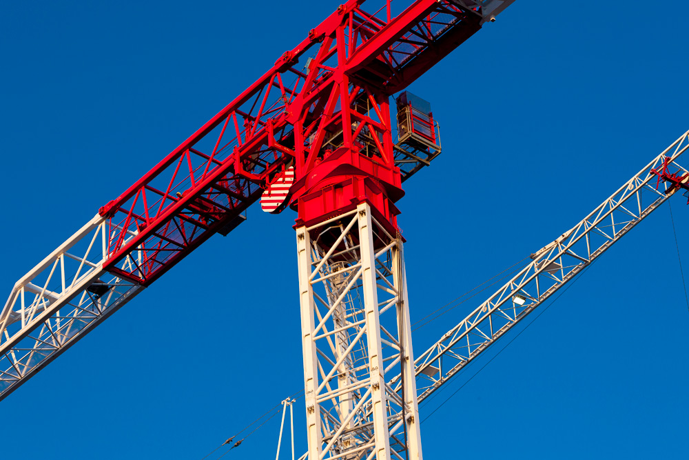 A closeup on a pair of construction cranes.